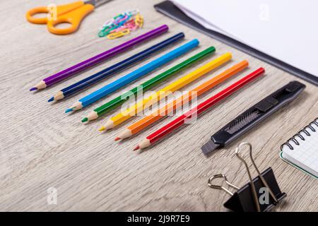 Torna a scuola nota libro, matite, Lope, mela verde su tavola di legno Foto Stock