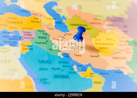 La spina blu punta verso l’Iran su una mappa politica del mondo Foto Stock