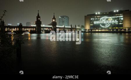 Berlino, Germania. 14th Apr 2022. Vista dal lato Kreuzberg dello Spree al Oberbaumbrücke e l'edificio universale di notte. Credit: Stefan Jaitner/dpa/Alamy Live News Foto Stock