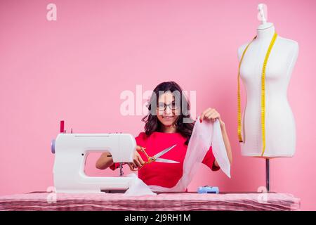 modello per cucire, macchina da cucire e manichetta in modello curvo rosa background.seamstress dello studio. su misura crea una collezione di abiti cuciti Foto Stock