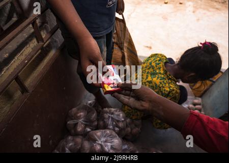 24 maggio 2022, Tehatta, Bengala Occidentale, India: Il governo del Bengala Occidentale ha diretto le scuole di governo di stato a distribuire le forniture di pasto di metà giorno ai genitori degli allievi durante le vacanze di estate in modo che i bambini bisognosi non siano privati del programma. L'avviso ha detto che ogni studente avrebbe ottenuto 2 kg di riso, 2 kg di patate, 250 grammi di zucchero, 250 grammi di legumi, e una saponetta. Così gli studenti sono venuti in una scuola elementare per ottenere i loro prodotti alimentari durante le vacanze estive e alcuni di loro stanno anche aiutando a dare gli articoli alimentari a Nabin Nagar, West Bengala. (Credit Image: © Soumrabyata Roy/Pacific Foto Stock