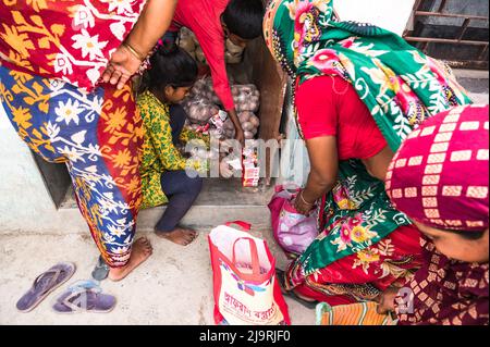 24 maggio 2022, Tehatta, Bengala Occidentale, India: Il governo del Bengala Occidentale ha diretto le scuole di governo di stato a distribuire le forniture di pasto di metà giorno ai genitori degli allievi durante le vacanze di estate in modo che i bambini bisognosi non siano privati del programma. L'avviso ha detto che ogni studente avrebbe ottenuto 2 kg di riso, 2 kg di patate, 250 grammi di zucchero, 250 grammi di legumi, e una saponetta. Così gli studenti sono venuti in una scuola elementare per ottenere i loro prodotti alimentari durante le vacanze estive e alcuni di loro stanno anche aiutando a dare gli articoli alimentari a Nabin Nagar, West Bengala. (Credit Image: © Soumrabyata Roy/Pacific Foto Stock