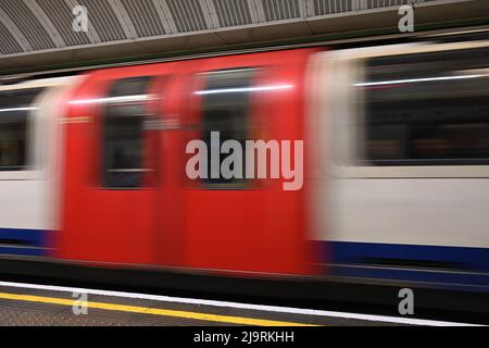 Una fotografia a bassa velocità dell'otturatore di un treno della metropolitana di Londra che passa attraverso la piattaforma fissa, mostrando il movimento del treno della metropolitana. Foto Stock