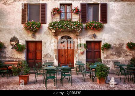 Italia, Toscana, Pienza. Tavoli e sedie allestiti all'aperto per cene all'aperto nella città di Pienza. Foto Stock