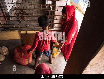 24 maggio 2022, Tehatta, Bengala Occidentale, India: Il governo del Bengala Occidentale ha diretto le scuole di governo di stato a distribuire le forniture di pasto di metà giorno ai genitori degli allievi durante le vacanze di estate in modo che i bambini bisognosi non siano privati del programma. L'avviso ha detto che ogni studente avrebbe ottenuto 2 kg di riso, 2 kg di patate, 250 grammi di zucchero, 250 grammi di legumi, e una saponetta. Così gli studenti sono venuti in una scuola elementare per ottenere i loro prodotti alimentari durante le vacanze estive e alcuni di loro stanno anche aiutando a dare gli articoli alimentari a Nabin Nagar, West Bengala. (Credit Image: © Soumrabyata Roy/Pacific Foto Stock