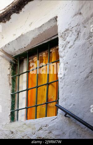 Le tende di colore arancione sulla finestra a townhouse soggiorno con la  Cinese-stile credenza nell'alcova accanto Edwardian camino Foto stock -  Alamy