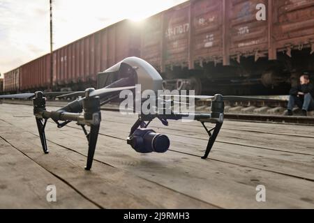 Un drone professionale si trova su un pavimento in legno, preparandosi al volo Foto Stock