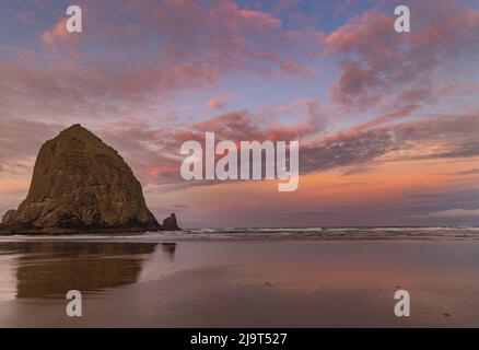 Alba nuvole su Haystack Rock a Cannon Beach, Oregon, Stati Uniti Foto Stock