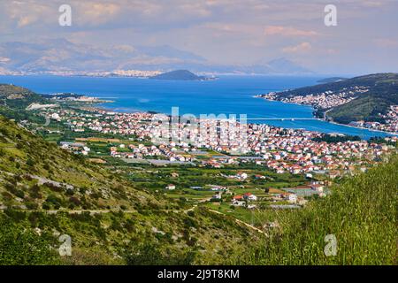Piccola cittadina croata sulla costa adriatica con un ponte per l'isola nel mare medio vicino a Spalato Foto Stock