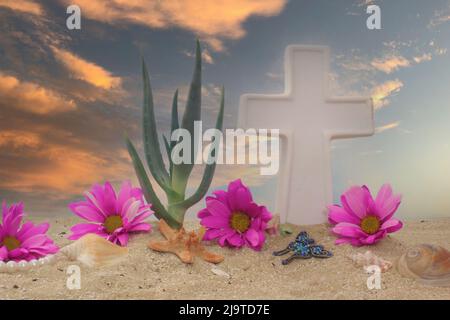 Conchiglie di mare e fiore su sabbia con Croce e Tramonto Foto Stock