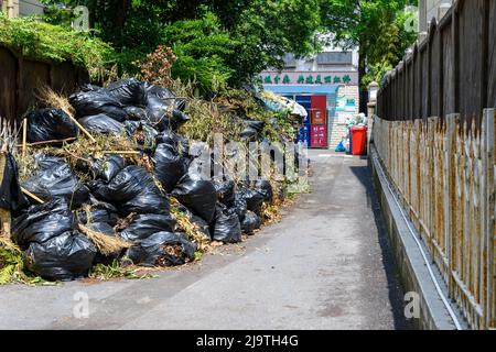 La discarica di rifiuti di un composto residenziale a Shanghai è traboccante perché il blocco ha impedito ai camion di smaltire i rifiuti. Foto Stock