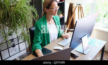 Una donna d'affari focalizzata lavora al computer in ufficio Foto Stock