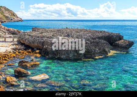 Spiaggia di roccia vulcanica sulla splendida baia a mezzogiorno d'estate. Foto Stock