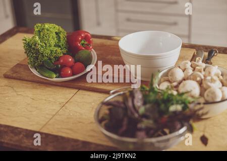 Verdure preparate per il taglio in insalata disposte sul tavolo in ciotole Foto Stock