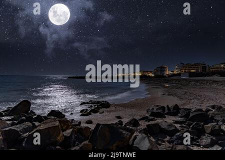 Località balneare tranquilla città di Pomorie con luci elettriche luminose e grandi e confortevoli hotel di lusso sullo sfondo di notte stellato blu cielo e ca Foto Stock