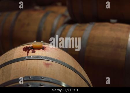 Botti di legno impilate in una cantina, produzione e maturazione del vino rosso nel modo tradizionale Foto Stock