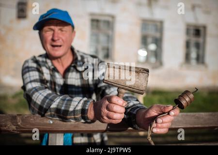 Un residente locale mostra i tradizionali attrezzi di tessitura della corda a Vylkove, regione di Odesa, Ucraina. Vylkove (o Vilkovo) è una città situata nella parte Ucraina del Delta del Danubio, al confine con la Romania. Le strade di Vylkove consistono in una rete di numerosi torrenti e canali navigabili, attraverso i quali i residenti si muovono sulle loro barche. Foto Stock