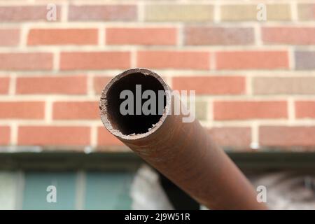 Vecchio tubo arrugginito che sporge dal muro. Foto Stock