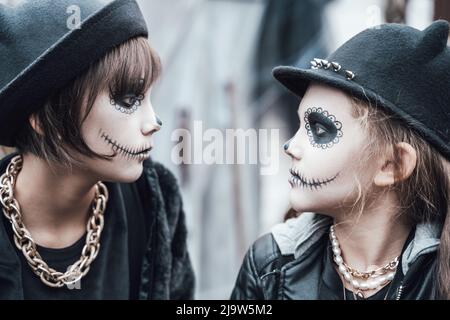 Spaventose bambine, sorelle che festeggiano Halloween. Terrificante bianco nero trucco viso per gli occhi, bocca, costumi strega, elegante image.Horror, divertimento a chil Foto Stock