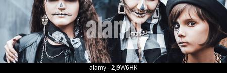 Famiglia spaventosa, madre, figlie che celebrano Halloween. Terrificante cranio nero mezza faccia trucco e costumi strega, elegante images.Horror, divertimento a childr Foto Stock