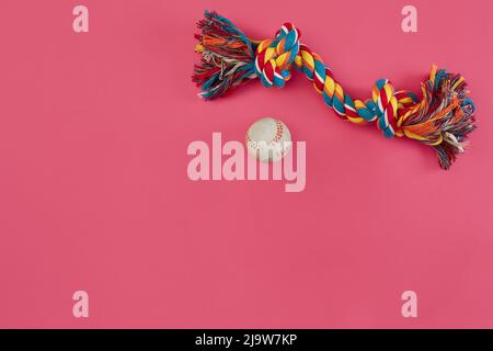 Giocattoli - corda e palla multicolore. Accessori per giocare su sfondo rosa vista dall'alto Foto Stock