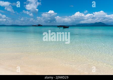 Spiaggia di sabbia con acqua pulita e trasparente con ondulazione e motivi a Semporna, Sabah, Borneo Foto Stock