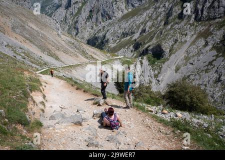 Gli escursionisti guardano una donna che è scattata sulle pietre nella gola di Cares (Rio Cares), una delle principali mete di escursioni spagnole per i visitatori del Parco Nazionale Picos de Europa, il 15th maggio 2022, vicino a Poncebo, Monti Picos, Asturie, Spagna. Conosciuta come la “Gola Divina”, il sentiero del 22km si estende tra Caín e Poncebos nelle Asturie tra montagne alte oltre 2.000 metri, lungo l'imponente burrone scolpito dal fiume Cares. Foto Stock