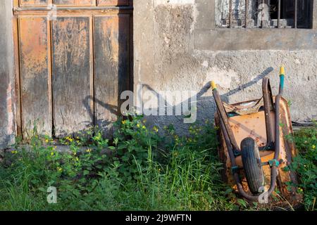 Carriola fuori di una proprietà agricola abbandonata e abbandonata in un villaggio rurale spagnolo, il 15th maggio 2022, a Mesta de con, Picos Mountains, Asturias, Spagna. Foto Stock