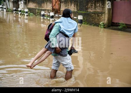 Guwahati, Assam, India. 25th maggio 2022. Un uomo ritorna sua figlia dalla scuola vaga attraverso una strada allagata dopo forti piogge, a Guwahati, Assam, India, il 25 maggio 2022. Il waterlogging è una scena comune nella città di Guwahati a causa del sistema di drenaggio povero. Credit: David Talukdar/Alamy Live News Foto Stock