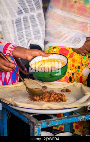 Cibo tradizionale - Stufati di carne con Injeira in Asmara, Eritrea Foto Stock