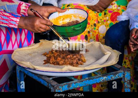Cibo tradizionale - Stufati di carne con Injeira in Asmara, Eritrea Foto Stock