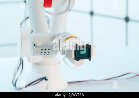 Braccio del robot con sensore di immagine a matrice CCD e CMOS nel manipolatore. Concetto sul tema della visione artificiale e del riconoscimento del modello Foto Stock