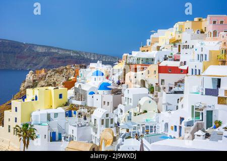 La cittadina di Oia sull isola di Santorini, Grecia. Tradizionale e famose case e chiese con le cupole blu sulla Caldera, il Mare Egeo Foto Stock