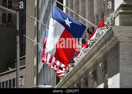 La bandiera americana e la bandiera di stato del Texas in mostra fuori della Borsa di New York (NYSE) il 25 maggio 2022 a New York Foto Stock