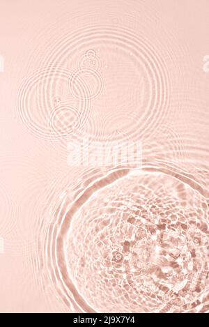 La consistenza dell'acqua su sfondo rosa. Foto Stock