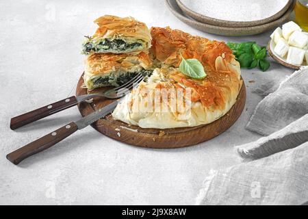 Deliziosa torta con spinaci e formaggio feta - spanakopita, cucina greca tradizionale. Foto Stock