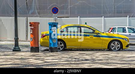 Un taxi giallo posto contro le caselle postali rossa e blu del servizio postale di Madeira. Il rosso è per la posta locale e il blu per la posta internazionale. Foto Stock