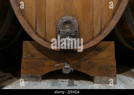 Interno di un'autentica cantina francese con vecchie botti di legno, invecchiamento di vino di alta qualità, primo piano. Foto Stock