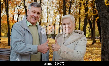 Ritratto di felice anziano caucasico famiglia moglie marito anziano nonni stand all'aperto in autunno parco sorridente anziano coppia matura donna uomo anziano Foto Stock