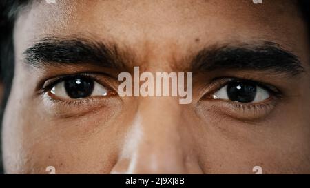 Estremo primo piano faccia di giovane arabo maschio adulto modello uomo occhi maschio con occhi scuri sguardo guardare la fotocamera mostra buona visione sana perfetto Foto Stock