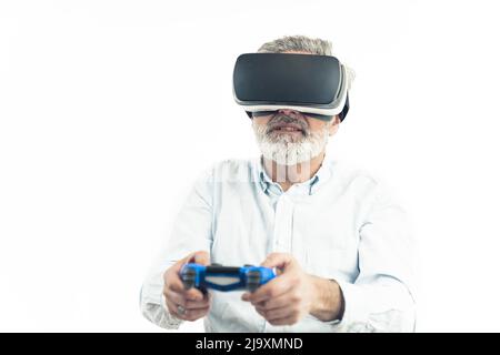 Uomo caucasico di mezza età con capelli grigio argento indossando Virtual Reality Googles e tenendo un Gamepad blu. Isolato su bianco. Foto di alta qualità Foto Stock