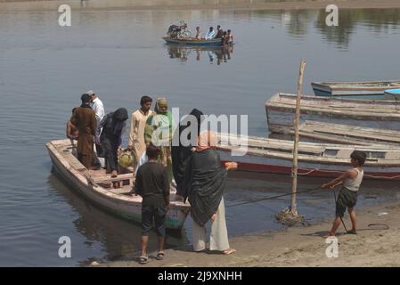 25 maggio 2022, Lahore, Punjab, Pakistan: Persone pakistane che trasportano le loro merci in barche per attraversare il fiume Ravi durante bloccato su strada a causa della chiusura delle rotte dopo l'applicazione dell'articolo 144 a causa di misure di sicurezza per la protesta e la lunga marcia della PTI verso Islamabad da Lahore. Mercoledì, le autorità pakistane hanno bloccato tutte le strade principali verso la capitale Islamabad, dopo che un ex primo ministro, Imran Khan, che ha detto di marciare con i dimostranti nel centro della città per un raduno che spera possa far crolere il governo e forzare le elezioni anticipate. (Credit Image: © Rana Sajid Hussai Foto Stock