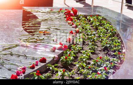 Memoriale commemorativo. Posa dei fiori al fuoco eterno. Omaggio alla memoria dei soldati caduti. Fiori e un saldatore per soldati. Foto Stock