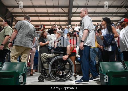 Uvalde, Stati Uniti. 25th maggio 2022. Texas Gov. GREG ABBOTT (in sedia a rotelle) lascia un servizio di guarigione a livello comunitario presso la zona fieristica della contea di Uvalde. L'evento segue un'azione di massa alla Robb Elementary School di Uvalde, dove martedì un cannoniere uccise 19 studenti e due insegnanti. Credit: Bob Daemmrich/Alamy Live News Foto Stock