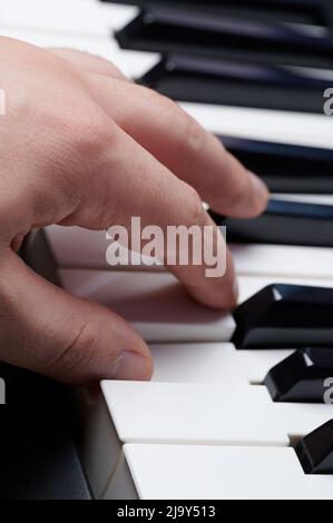 Riproduzione con una mano su piano macro vista ravvicinata Foto Stock