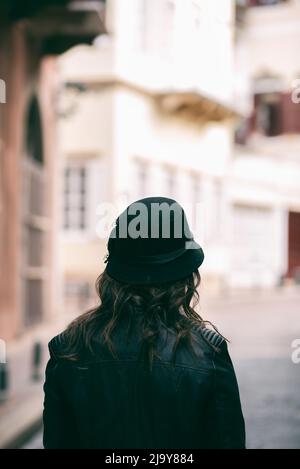 Vista posteriore della donna che indossa giacca in pelle per strada Foto Stock