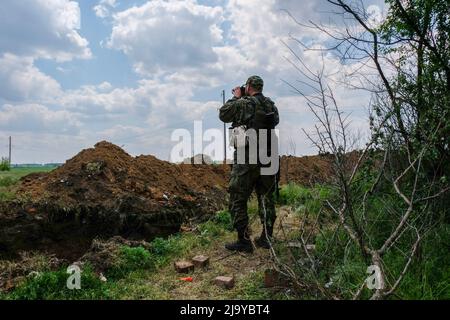 Soledar, Ucraina. 24th maggio 2022. Un soldato guarda attraverso il binocolo. Soledar è una città della regione di Donetsk, è stata martellato dall'artiglieria russa in quanto si trova lungo la strada cruciale che conduce fuori di Severodonetsk assediata. (Foto di Rick Mave/SOPA Images/Sipa USA) Credit: Sipa USA/Alamy Live News Foto Stock