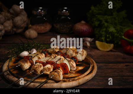 Chiudi i gustosi spiedini di pollo alla griglia con pomodoro, pepe dolce e cipolle sul tagliere pronto per servire Foto Stock