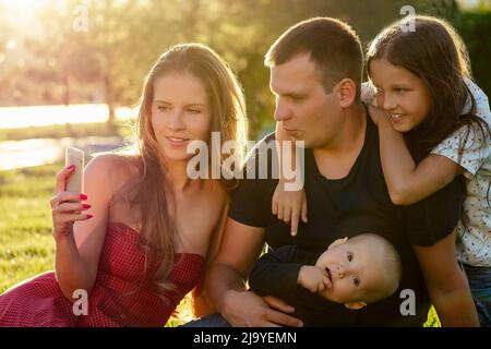 bella famiglia fotosessione . bella madre (donna), bel padre (uomo) con una bambina figlia (scolgirl) e bambino ragazzo figlio fotografato Foto Stock