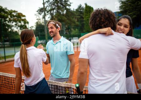 Gruppo di giocatori di tennis che danno una stretta di mano dopo una partita Foto Stock